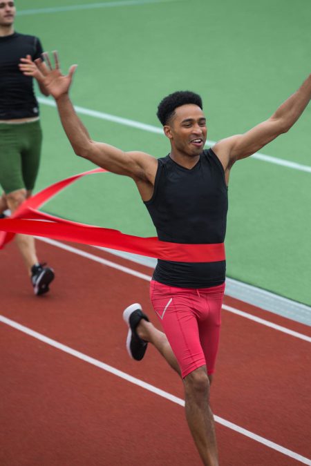 Handsome african athlete man crossing finish line